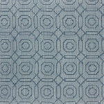 Handwoven rug sample with a raised loop circle and diamond pattern in shades of blue. 