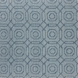 Handwoven rug sample with a raised loop circle and diamond pattern in shades of blue. 