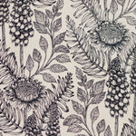 Detail of wallpaper in a dense floral print in black and white on a cream field.