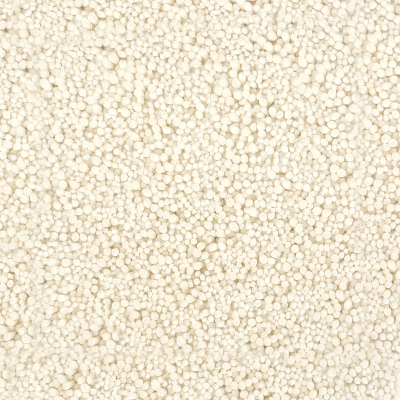 A close-up texture shot of a handtufted rug, showing the looped pile texture in a solid cream color.