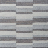 Flatweave rug in a broken stripe in shades of grey and cream.