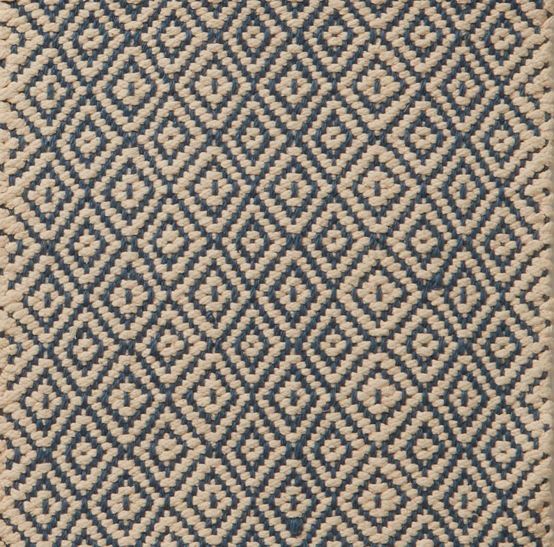 Flatwoven rug in a diamond pattern in blue and cream.