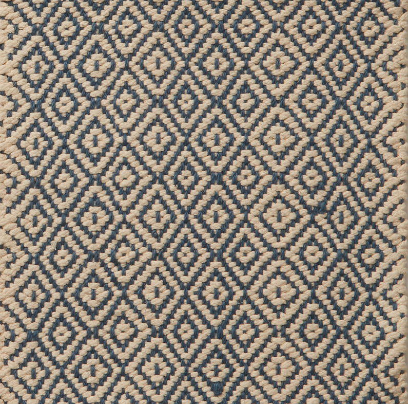 Flatwoven rug in a diamond pattern in blue and cream.