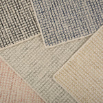 Stack of broadloom carpet samples in a checkered pattern in a range of colors. 