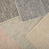 Stack of broadloom carpet samples in a checkered pattern in a range of colors. 