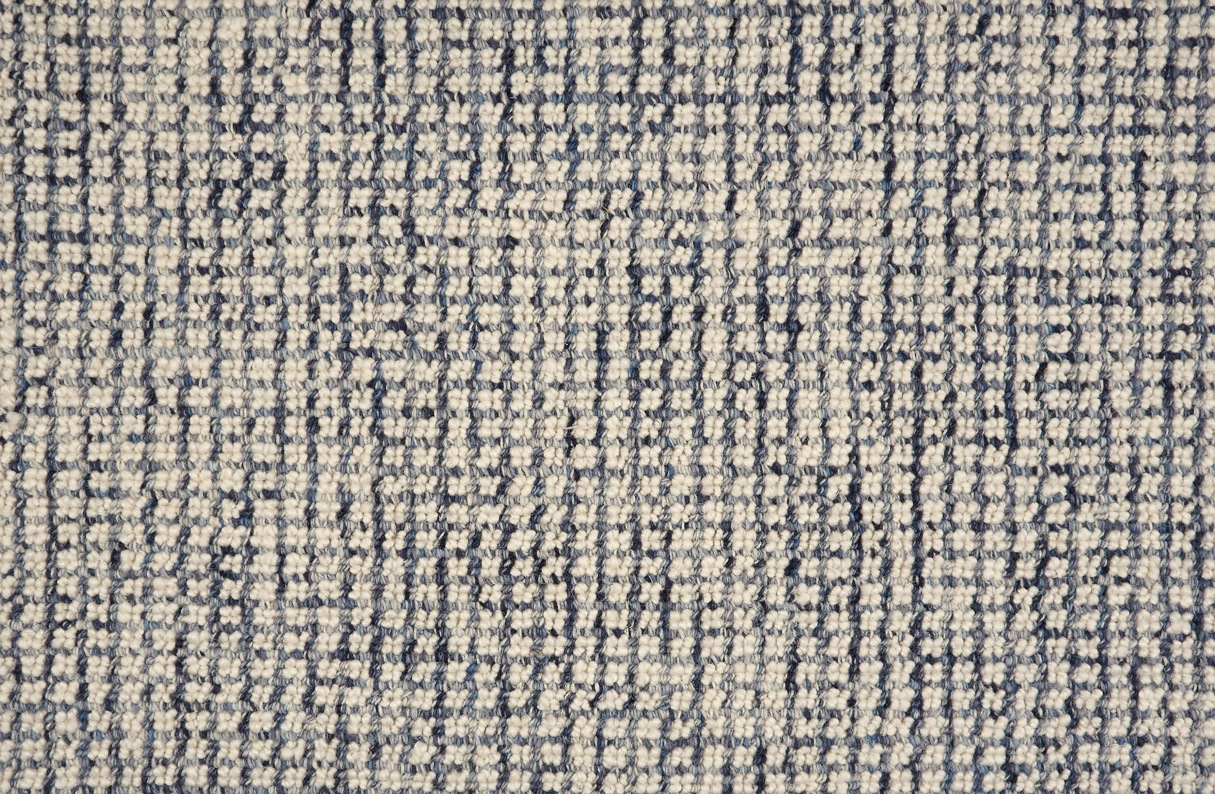 Broadloom carpet in a textural checkered pattern in ivory and blue.