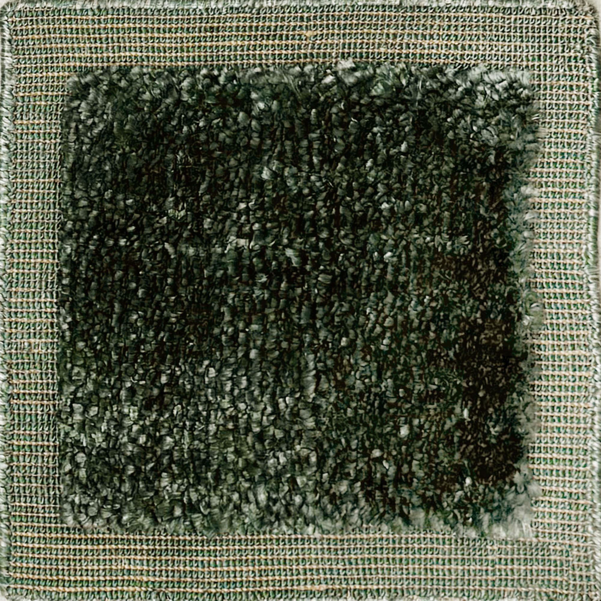 Handloomed rug with green-tan border and raised cut pile shag field in forest green.