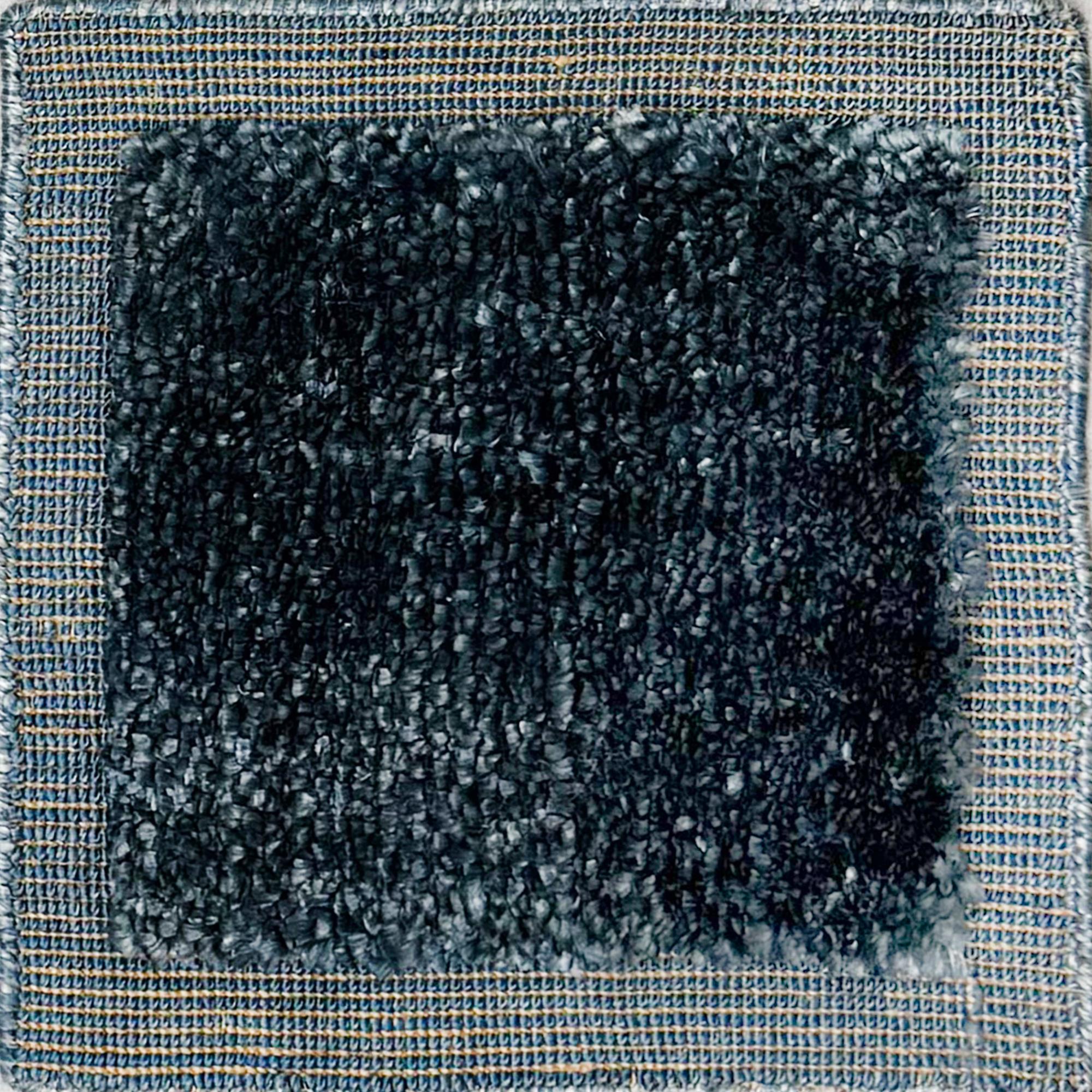 Handloomed rug with blue-tan border and raised cut pile shag field in midnight blue.