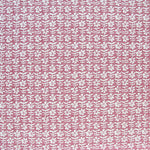 Detail of fabric in a floral grid print in white and red on a pink field.