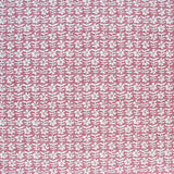 Detail of fabric in a floral grid print in white and red on a pink field.