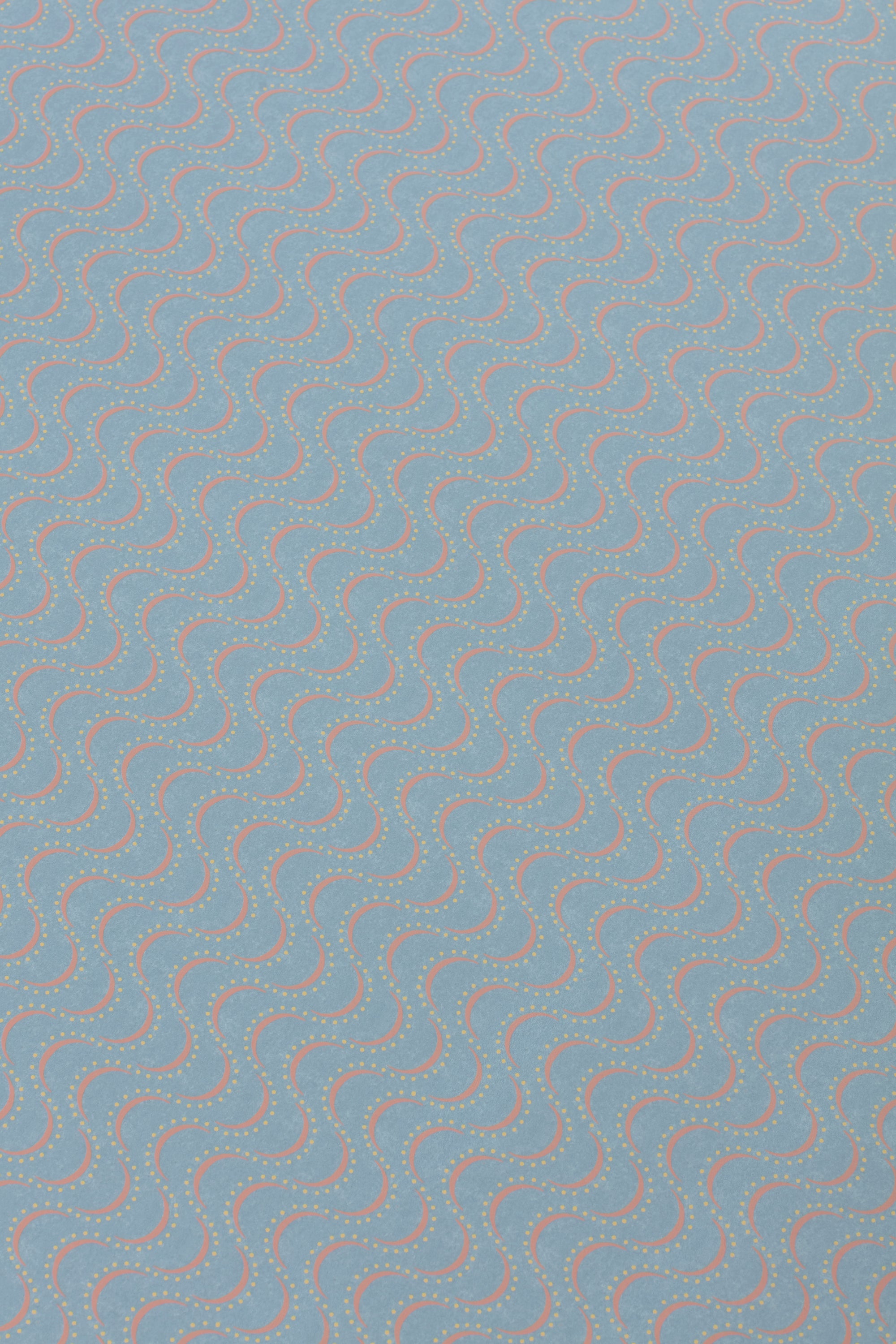 Detail of a wallpaper panel in an undulating stripe pattern in yellow and coral on a light blue field.