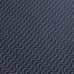 Detail of a wallpaper panel in an undulating stripe pattern in white and mustard on a dark navy field.