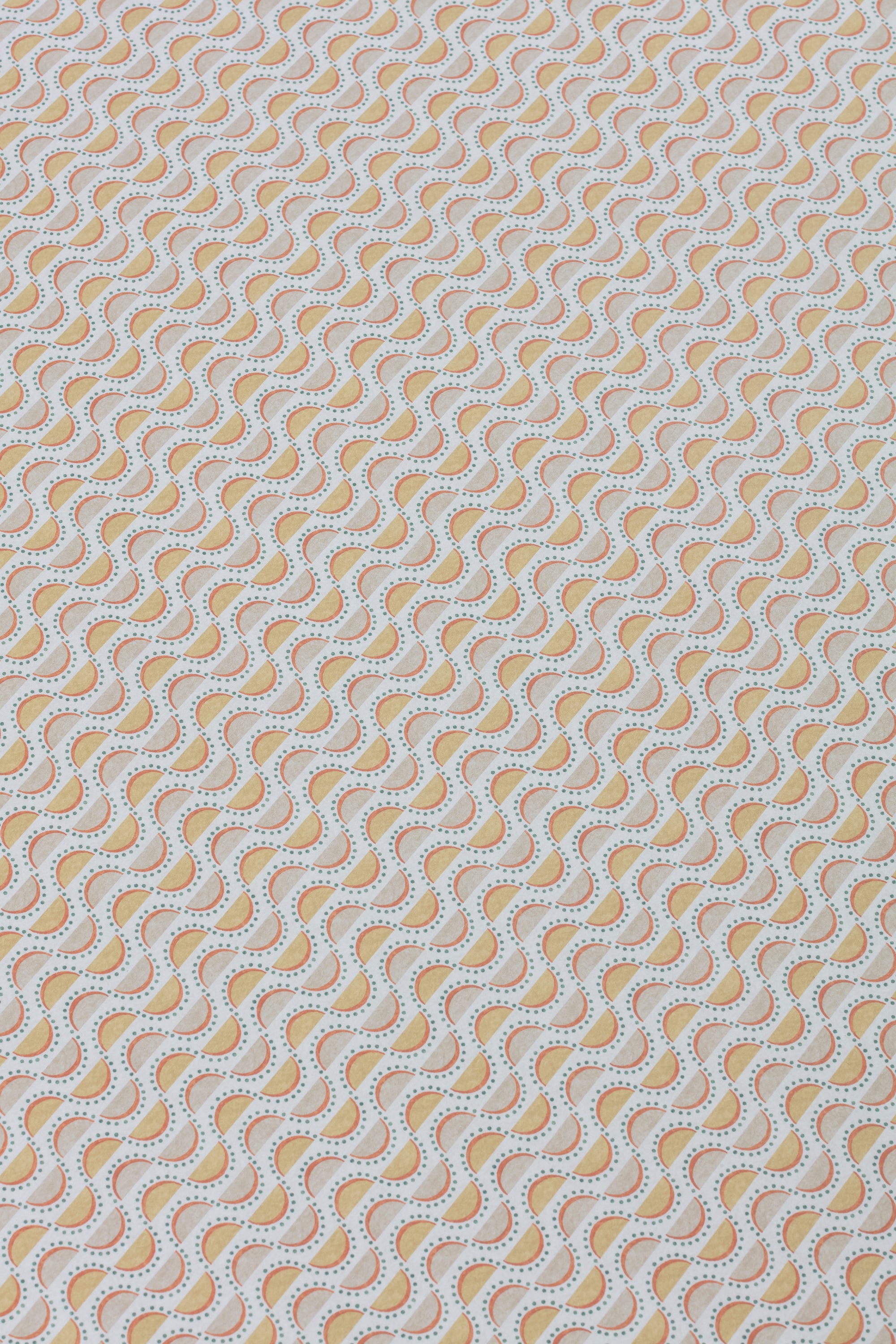 Detail of a wallpaper panel in a linear geometric print in shades of purple, blue and yellow on a light blue field.
