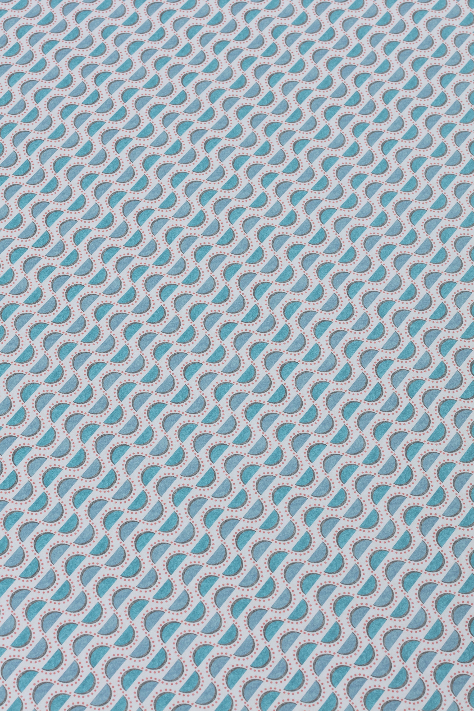 Detail of a wallpaper panel in a linear geometric print in shades of blue and pink on a light blue field.