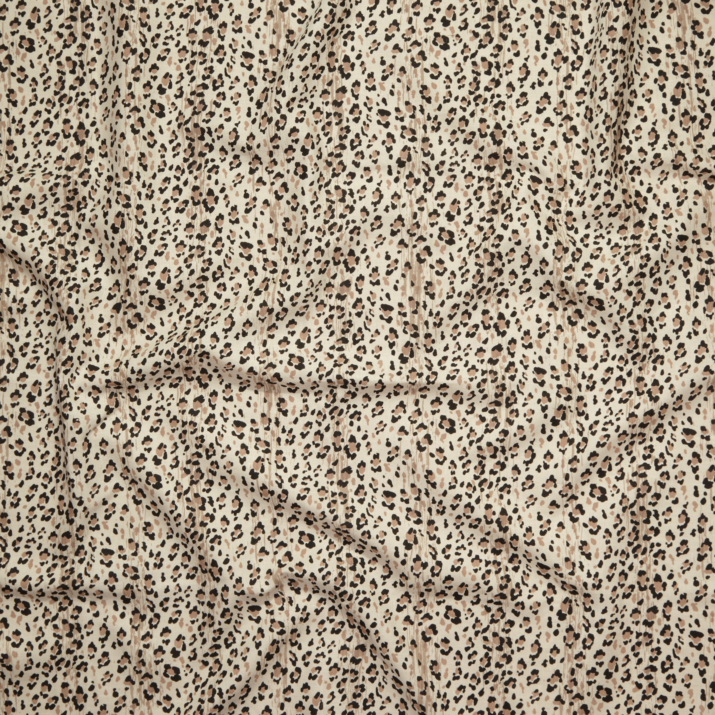Close up of gently draped printed linen with small scale painterly animal print in black and tan on a beige background