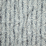 Close up of gently draped printed linen with small scale painterly animal print in navy and light blue on a white background