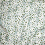 Close up of gently draped Indoor-Outdoor fabric with a painterly animal print in light blue and green on white. 