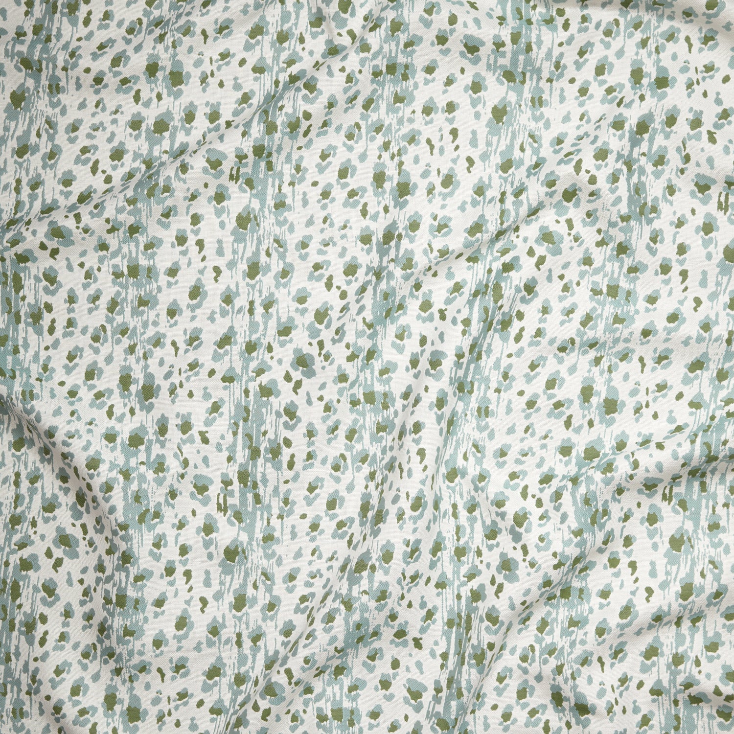 Close up of gently draped Indoor-Outdoor fabric with a painterly animal print in light blue and green on white. 