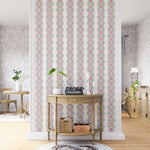 A maximalist living space with an accent wall papered in an intricate diamond stripe print in red, black and cream.