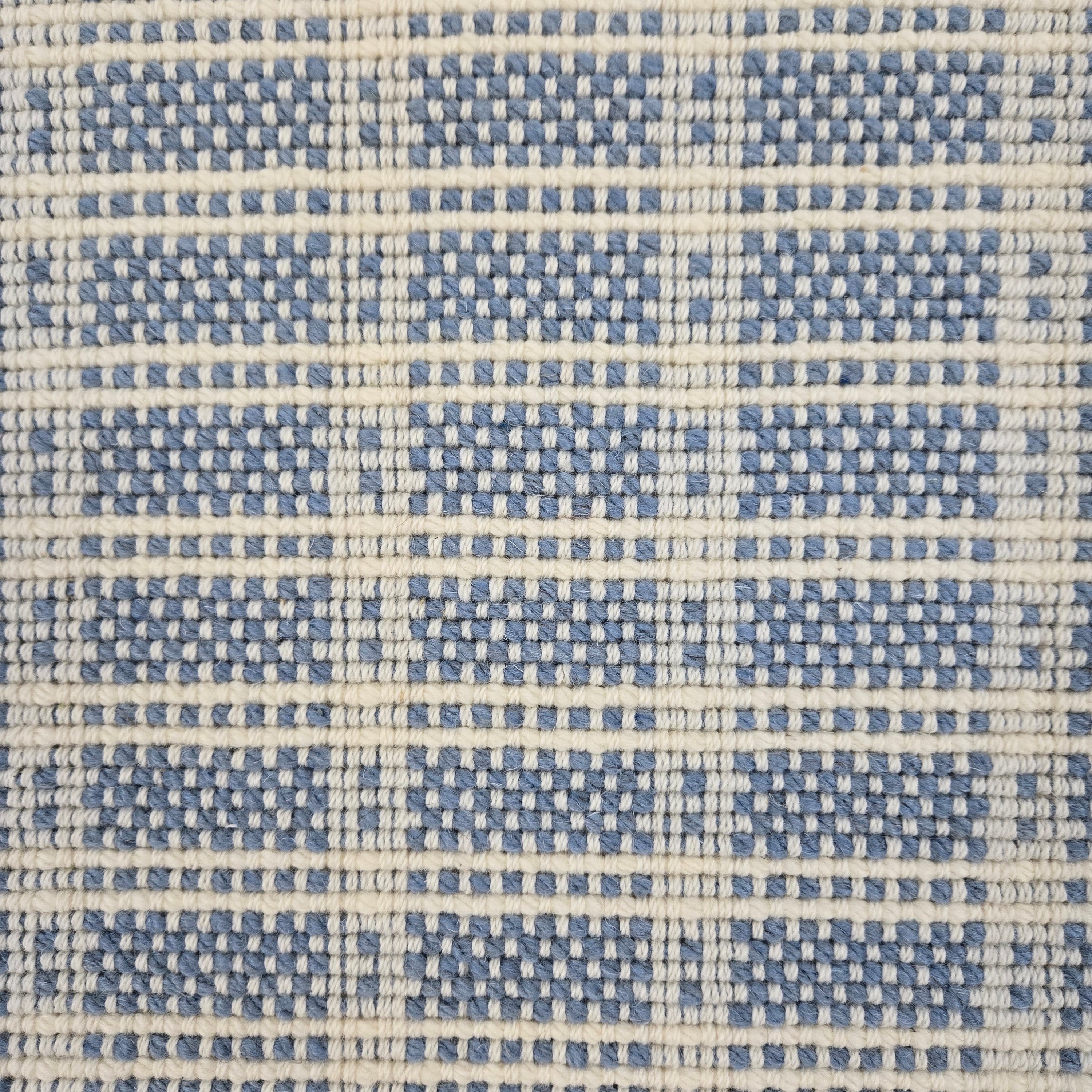 Broadloom carpet in slim plaid pattern in cream and blue.