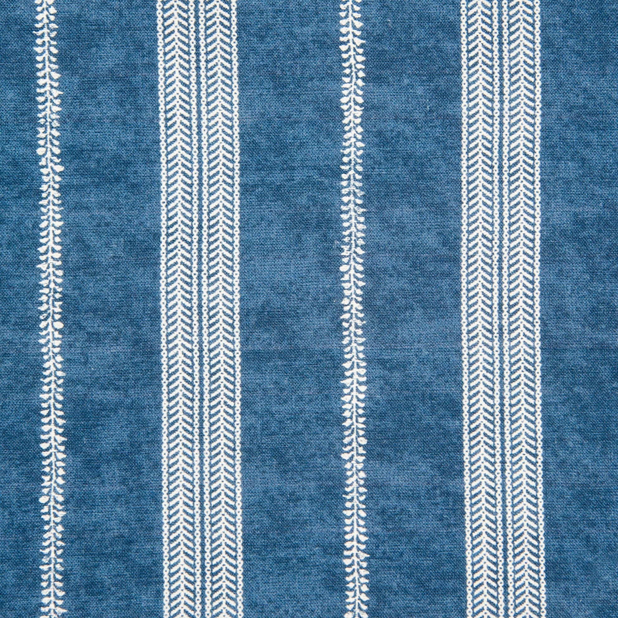 Detail of fabric in a small-scale botanical stripe print in white on an indigo field.
