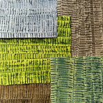 Pile of wallpaper swatches with undulating ribbon patterns in shades of blue, green, gray and brown.