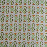 Close up of printed fabric with green squiggles, orange striped triangles, light green X marks on a broken grid in blue on a white background. 