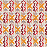 Close up of printed wallpaper with red squiggles, pink striped triangles, orange  X marks on a broken grid in orange on a white background. 