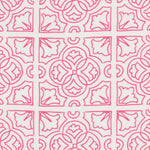 Detail of fabric in a damask lattice print in magenta on a white field.