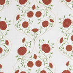 Detail of fabric in a floral lattice print in red, orange and green on a cream field.