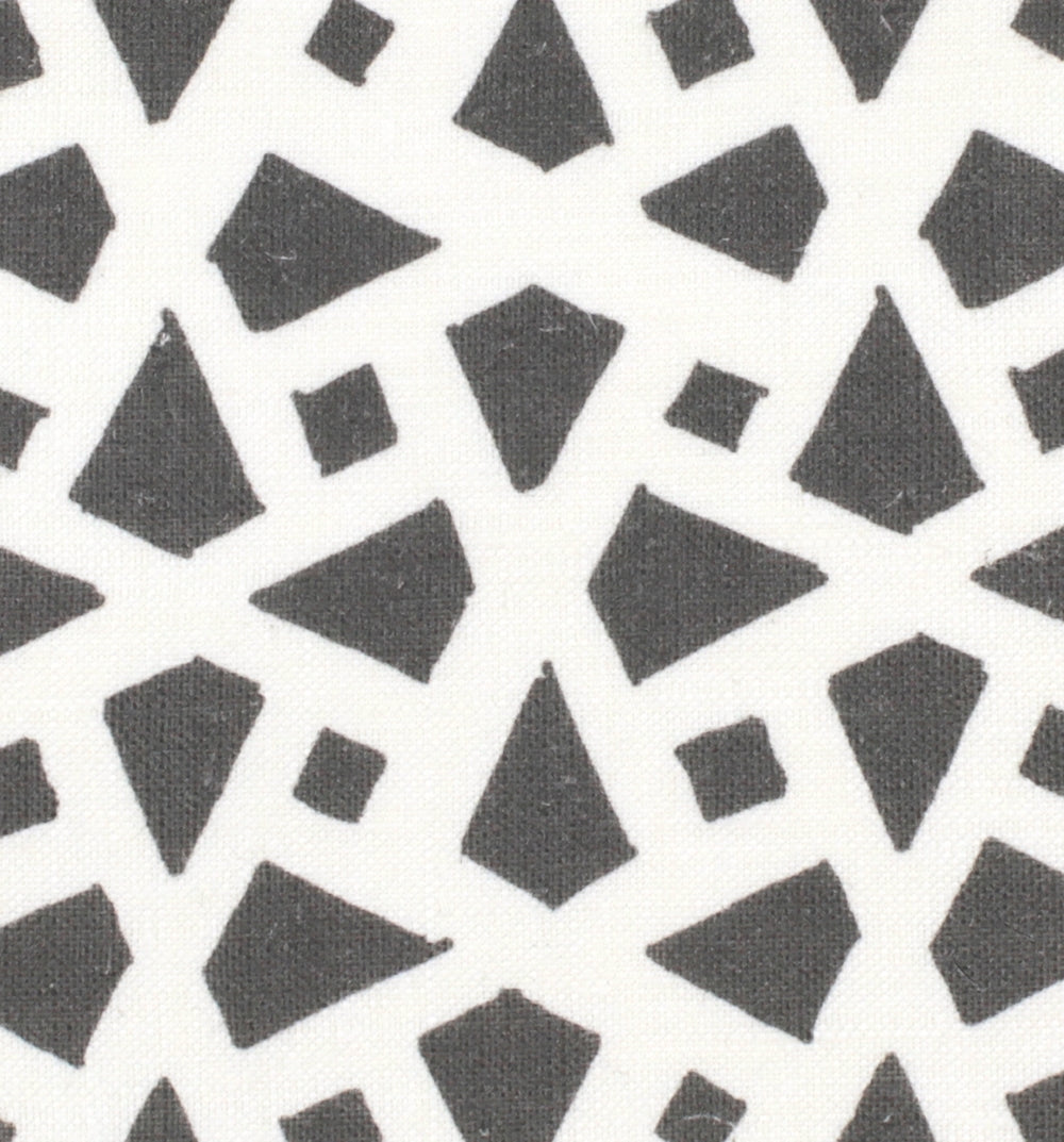 Detail of fabric in a geometric lattice print in charcoal on a white field.
