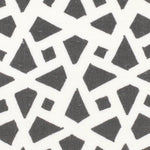 Detail of fabric in a geometric lattice print in charcoal on a white field.