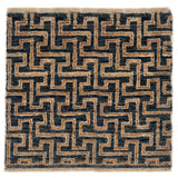A square area rug with a geometric maze-like pattern in black and tan, finished with a fringed edge.