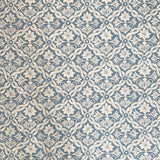 Detail of fabric in a floral lattice print in cream on a light blue field.