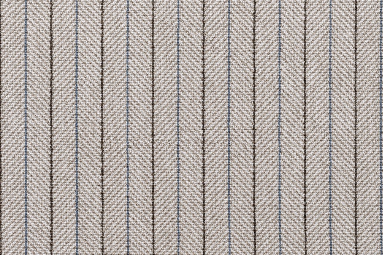 Broadloom carpet in a taupe herringbone stripe with brown and blue pinstripes. 