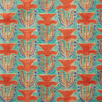 Fabric swatch with a stamped painted floral motif in vibrant red and cobalt on an emerald green background