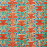 Fabric swatch with a stamped painted floral motif in vibrant red and cobalt on an emerald green background