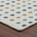 Patterned rug with multicolored dots on a wooden floor