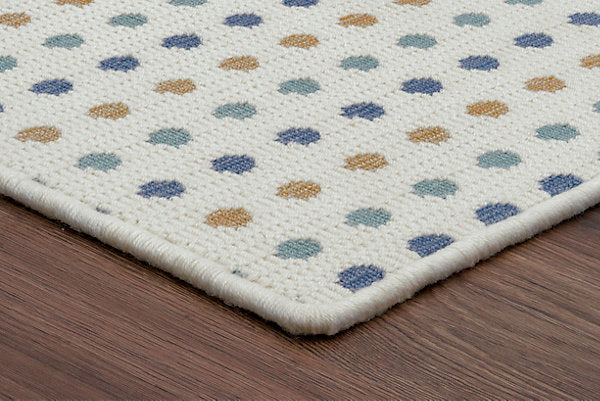 Patterned rug with multicolored dots on a wooden floor