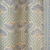 Draped printed linen in a playful dense blue and yellow with radiating green lines on a cream field. 