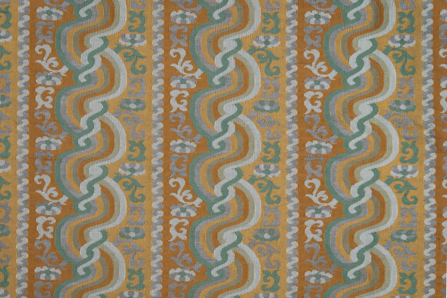 Handwoven silk fabric with scrolling stripe design in orange, green, yellow, grey and white. 