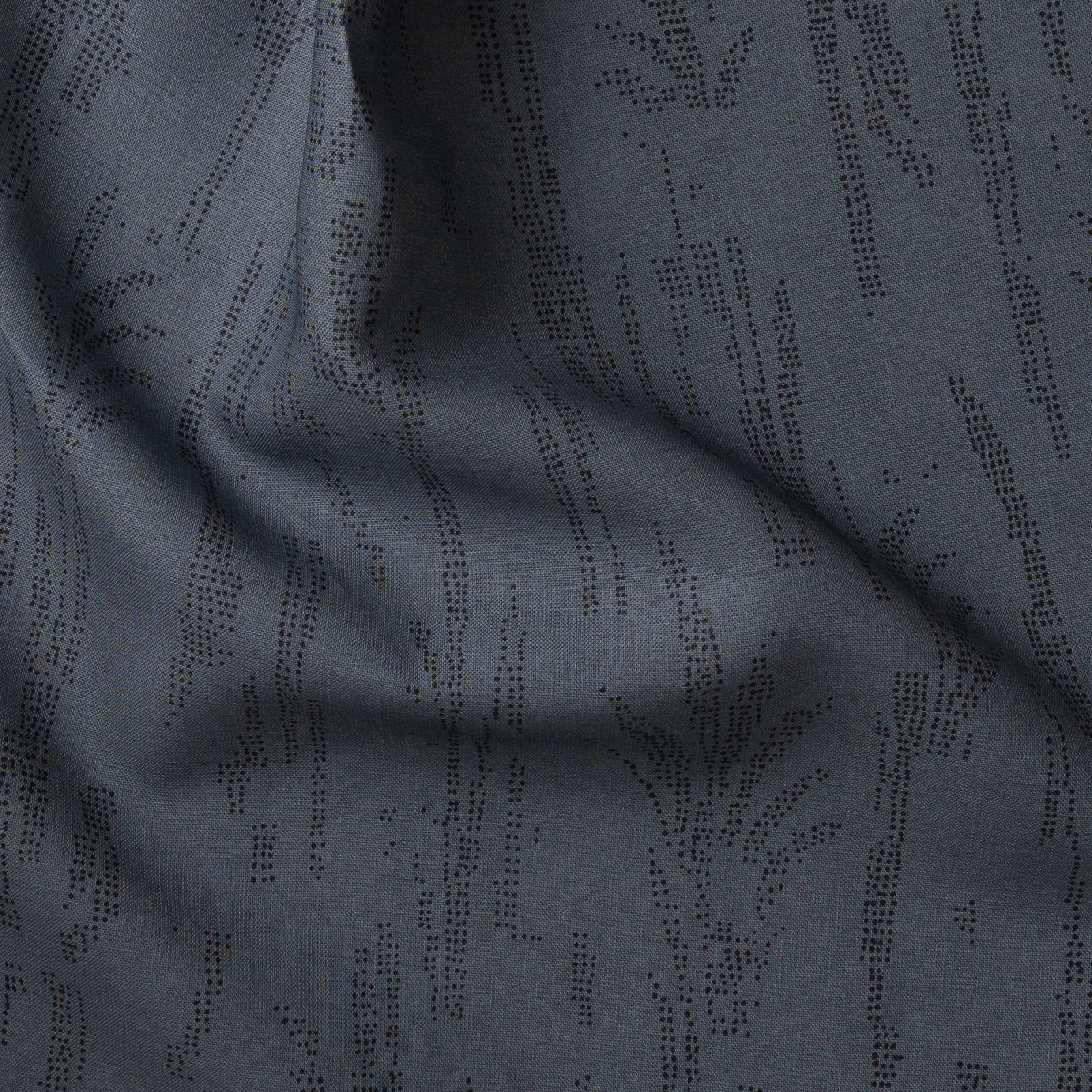 Detail of gently draped printed fabric with a black pointillist wheat frond pattern on a dark blue background. 