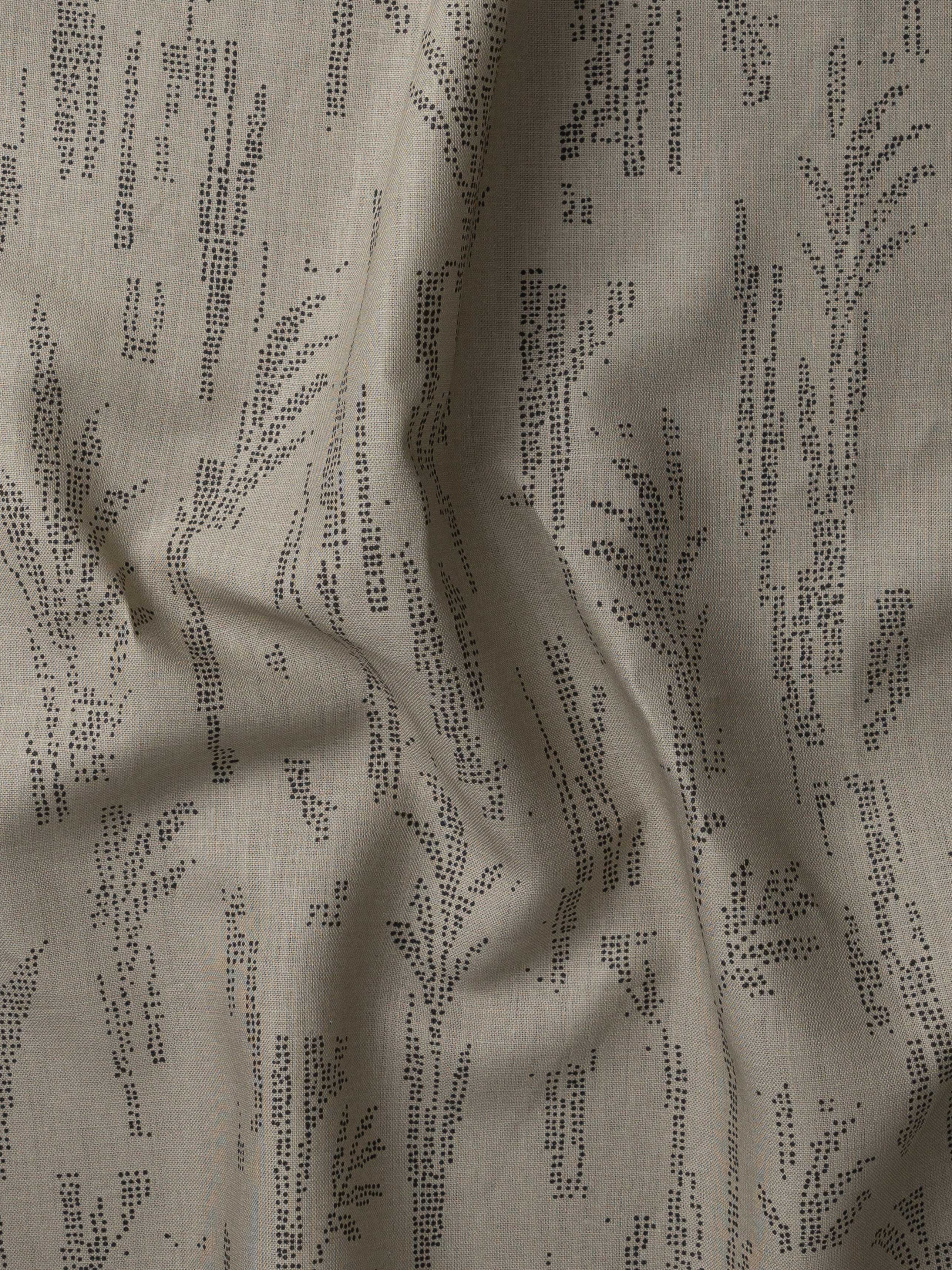 Detail of gently draped printed fabric with a black pointillist wheat frond pattern on a taupe background. 