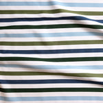 Close up of gently draped striped woven Indoor-Outdoor fabric in white, light blue, olive green, navy blue and dark green.