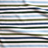 Close up of gently draped striped woven Indoor-Outdoor fabric in white, light blue, olive green, navy blue and dark green.