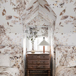 Small bedroom with floral wallpaper, wooden dresser, and bed.