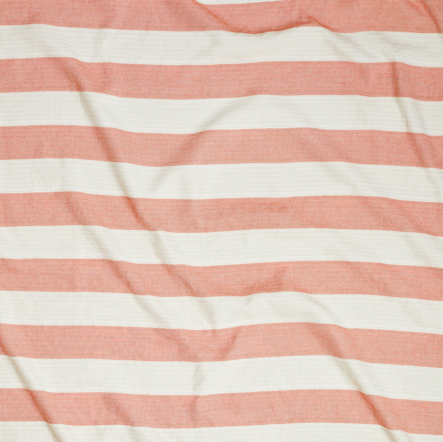 Close up of gently draped woven Indoor-Outdoor fabric with wide stripes in white and coral red