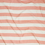 Close up of gently draped woven Indoor-Outdoor fabric with wide stripes in white and coral red
