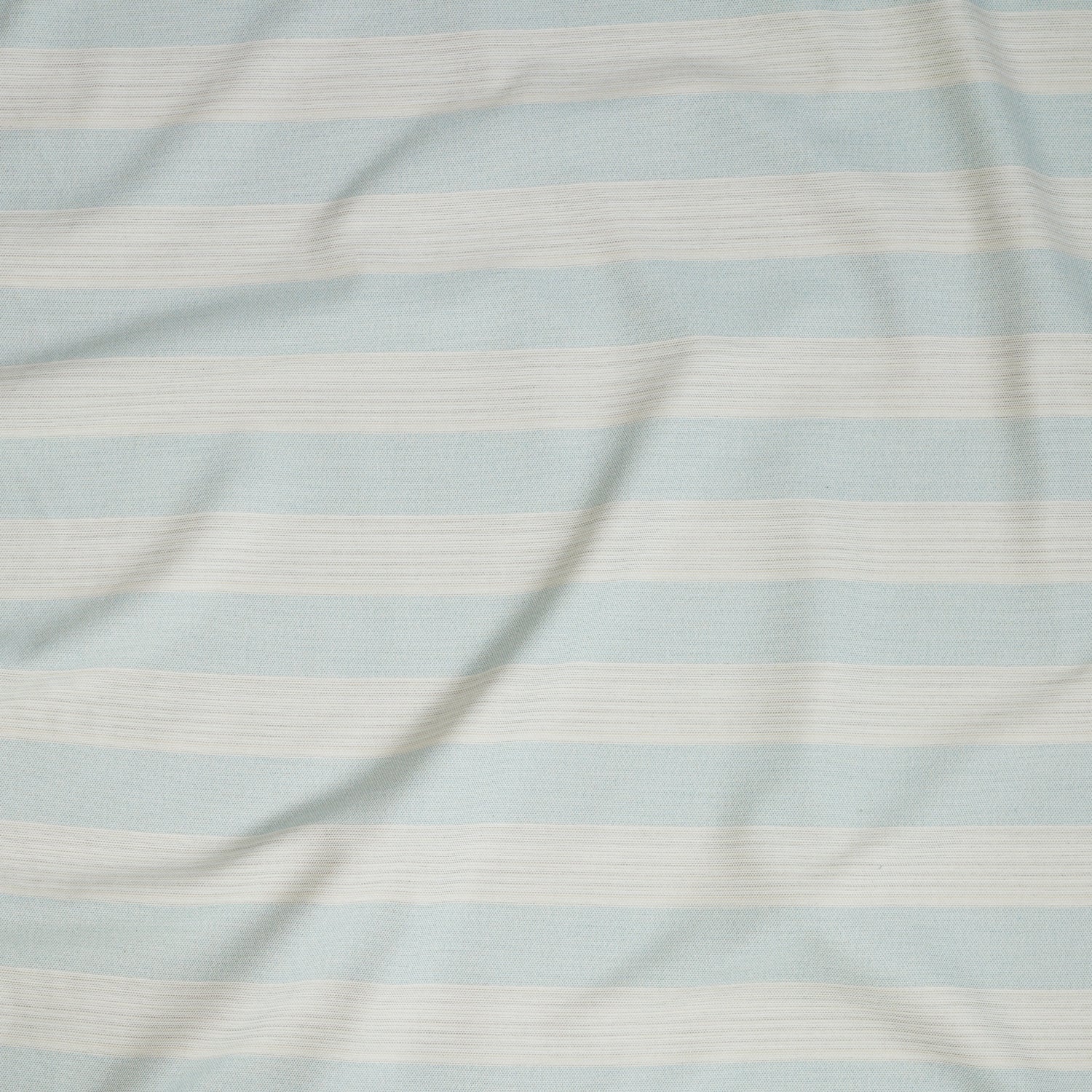 Close up of gently draped woven Indoor-Outdoor fabric with wide stripes in white and light blue.