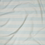 Close up of gently draped woven Indoor-Outdoor fabric with wide stripes in white and light blue.